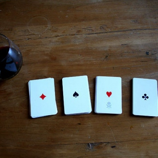 A deck of cards and a bottle of wine on a rainy Saturday night